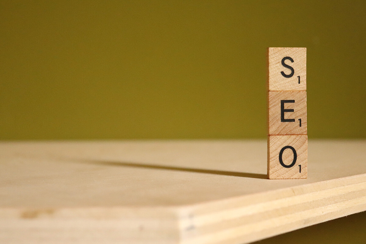 The letters S, E, and O in wooden cubes stacked on top of each other on a wooden table