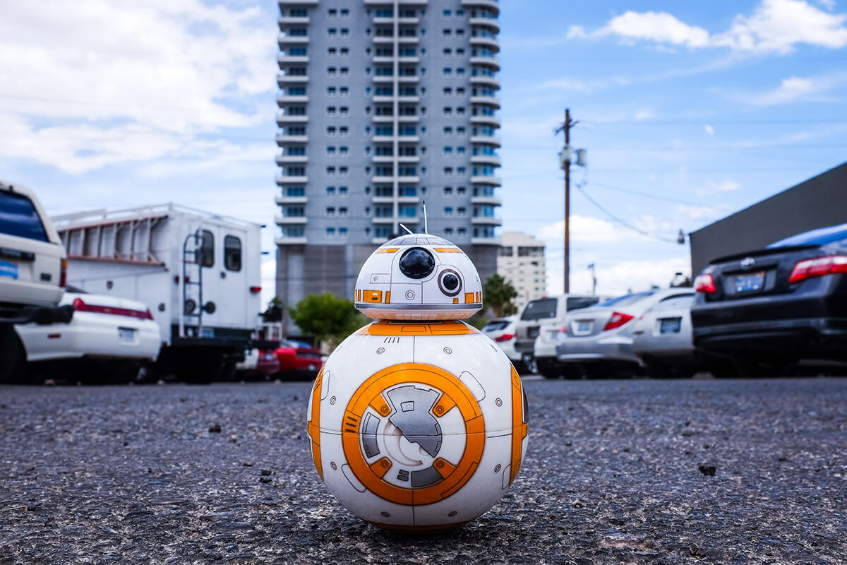 BB-8 from Star Wars in a parking lot with cars around him